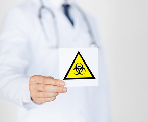 Image showing male doctor holding boihazard caution sign