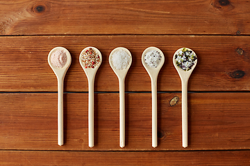 Image showing spoons with salt and spices on wooden table