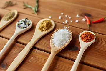 Image showing spoons with spices and salt on wooden table