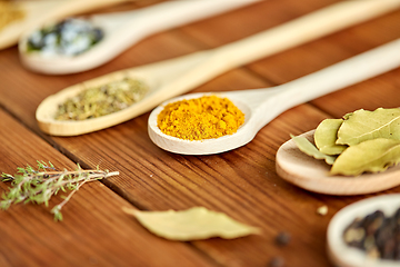 Image showing spoons with different spices on wooden table