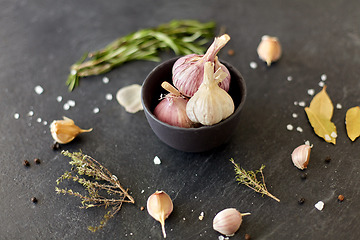 Image showing garlic in bowl and rosemary on stone surface