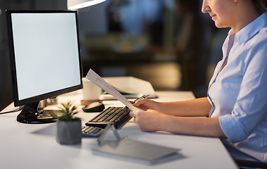 Image showing businesswoman with papers working at night office