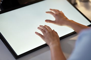 Image showing hands on led light tablet at night office