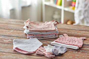 Image showing baby clothes on wooden table at home