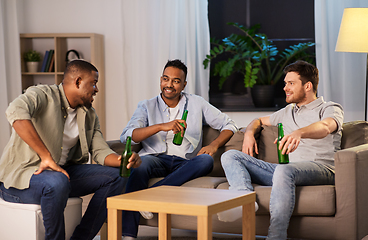 Image showing happy male friends drinking beer at home at night