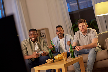 Image showing happy friends playing video games at home at night