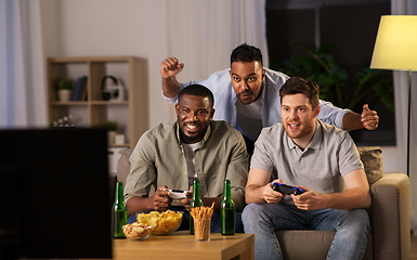 Image showing happy friends playing video games at home at night