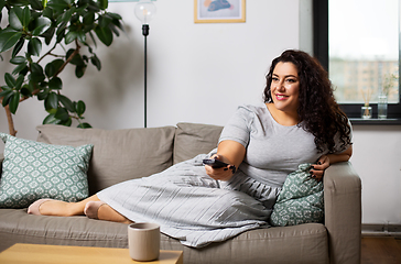 Image showing woman with remote control and watching tv at home