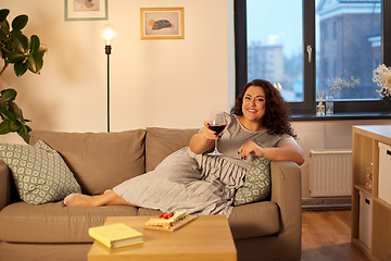 Image showing happy woman drinking red wine at home in evening