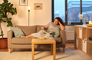 Image showing woman reading book at home in evening