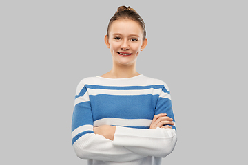 Image showing smiling teenage girl with crossed arms in pullover