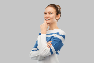 Image showing smiling teenage girl in pullover thinking