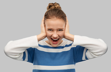 Image showing teenage girl closing ears by hands and screaming