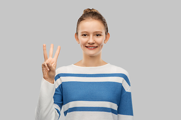 Image showing smiling teenage girl showing three fingers