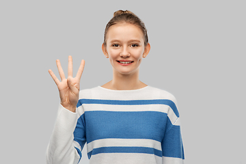 Image showing smiling teenage girl showing four fingers