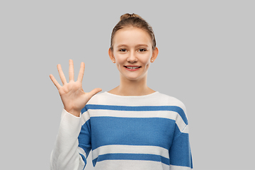 Image showing smiling teenage girl showing five fingers