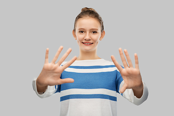 Image showing smiling teenage girl showing hands or ten fingers