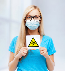 Image showing woman in medical mask with boihazard caution sign