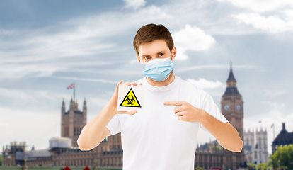 Image showing man in medical mask with biohazard sign in england