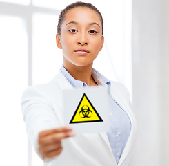 Image showing female doctor holding boihazard caution sign