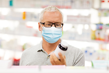 Image showing senior man in medical mask with drug at pharmacy