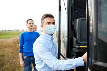 Image showing male passenger in medical mask boarding travel bus