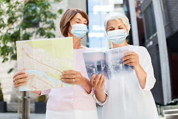 Image showing senior women in masks with travel map in city