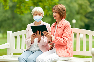 Image showing old women in medical mask with tablet pc at park
