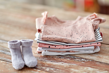 Image showing baby clothes on wooden table at home