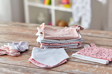 Image showing baby clothes on wooden table at home