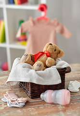 Image showing teddy bear toy in basket with baby things on table