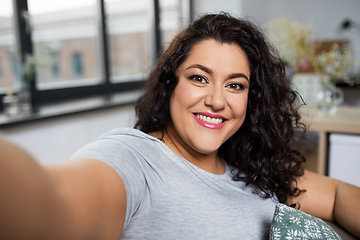 Image showing happy smiling young woman taking selfie at home