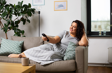Image showing woman with remote control and watching tv at home