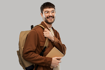 Image showing smiling young man with backpack and diary