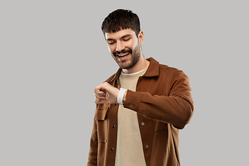 Image showing smiling young man with smart watch