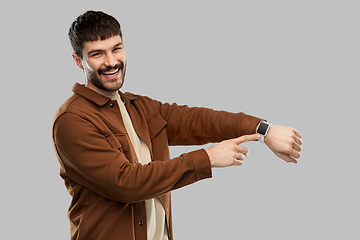 Image showing smiling young man with smart watch