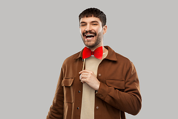 Image showing smiling man with red bowtie party accessory