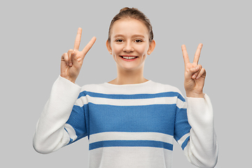 Image showing smiling teenage girl showing peace hand sign