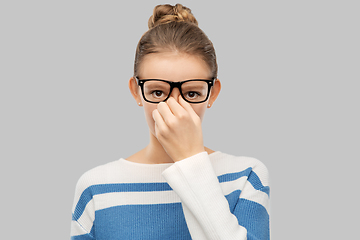 Image showing teenage girl in glasses rubbing nose bridge