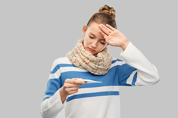 Image showing sick teenage girl in scarf measuring temperature