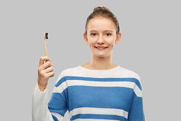 Image showing happy teenage girl with wooden eco toothbrush