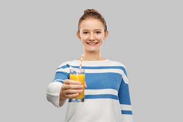 Image showing smiling teenage girl holding glass of orange juice