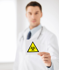 Image showing male doctor holding boihazard caution sign