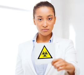 Image showing female doctor holding boihazard caution sign