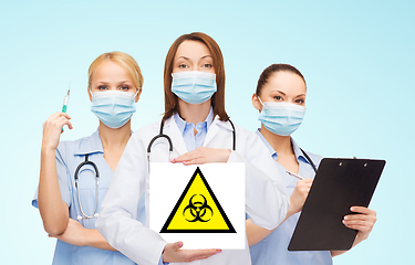 Image showing female doctor and nurses with biohazard sign