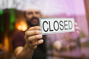 Image showing owner puts closed sign at bar or restaurant window