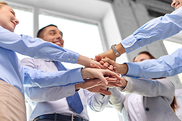 Image showing close up of business team stacking hands at office