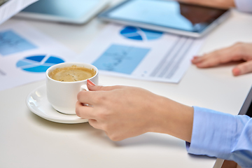 Image showing hand of businesswoman drinking coffee at office