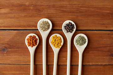 Image showing spoons with different spices on wooden table