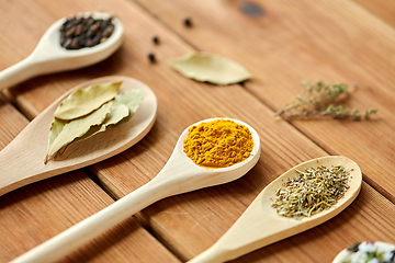 Image showing spoons with different spices on wooden table